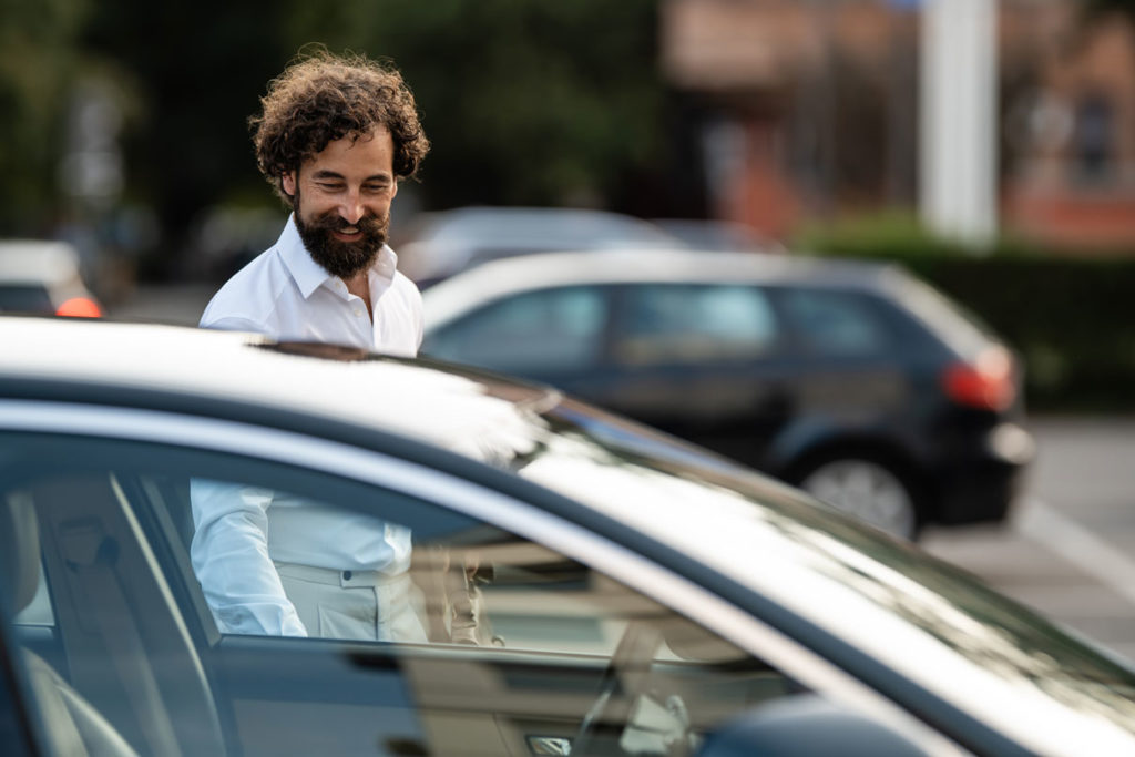 Mitarbeiter steigt aus parkendem Auto auf Mitarbeiterparkplatz aus