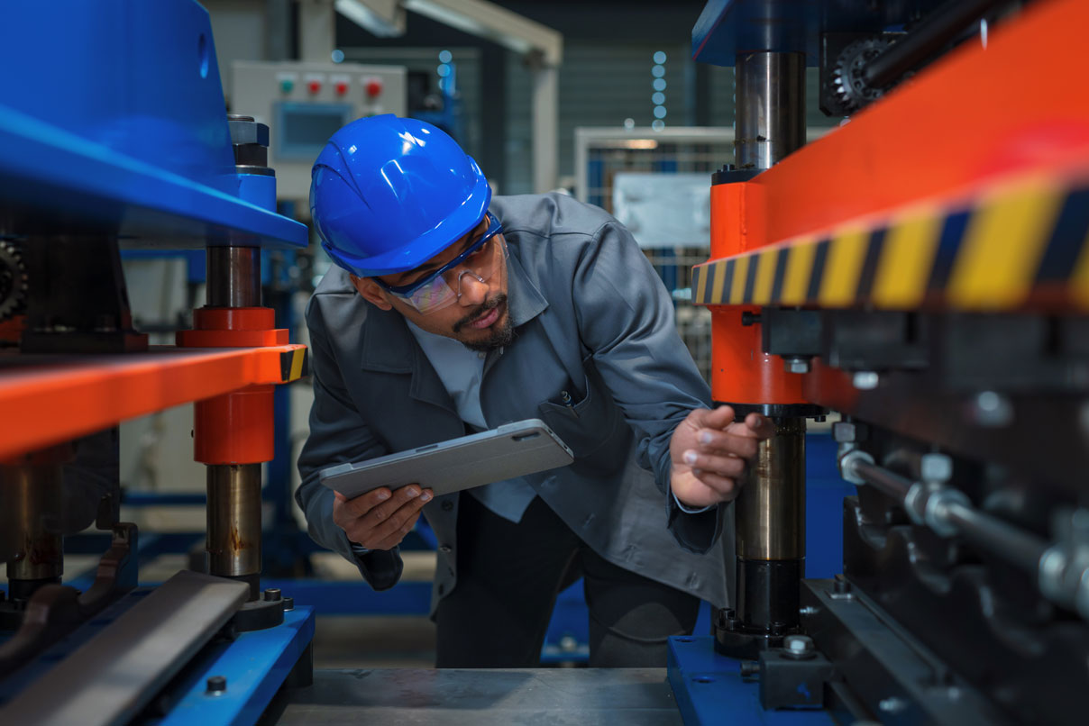Prüfung einer Maschine durch einen Mitarbeiter