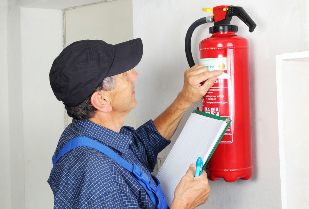 Fachmann bei der Pr�fung eines Feuerl�schers 
